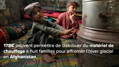 Enfants prêts d'un appareil de chauffage en Afghanistan
